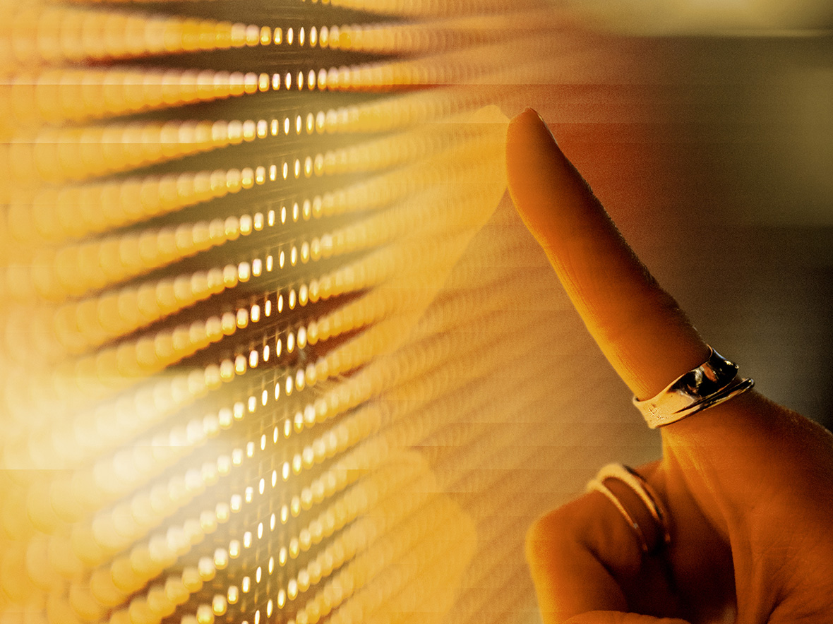 Image close up of hand touching lit up screen